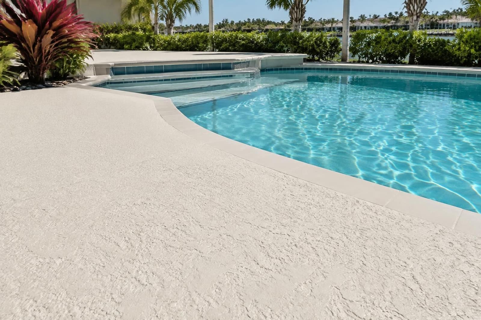 Pale knockdown spray-deck coating around a bright South Florida swimming pool